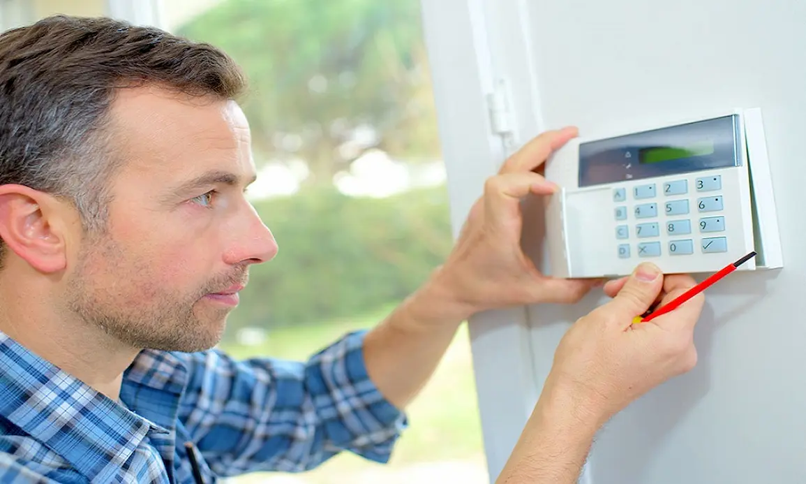 Technician installing intrusion detection system for enhanced building security and unauthorized access prevention