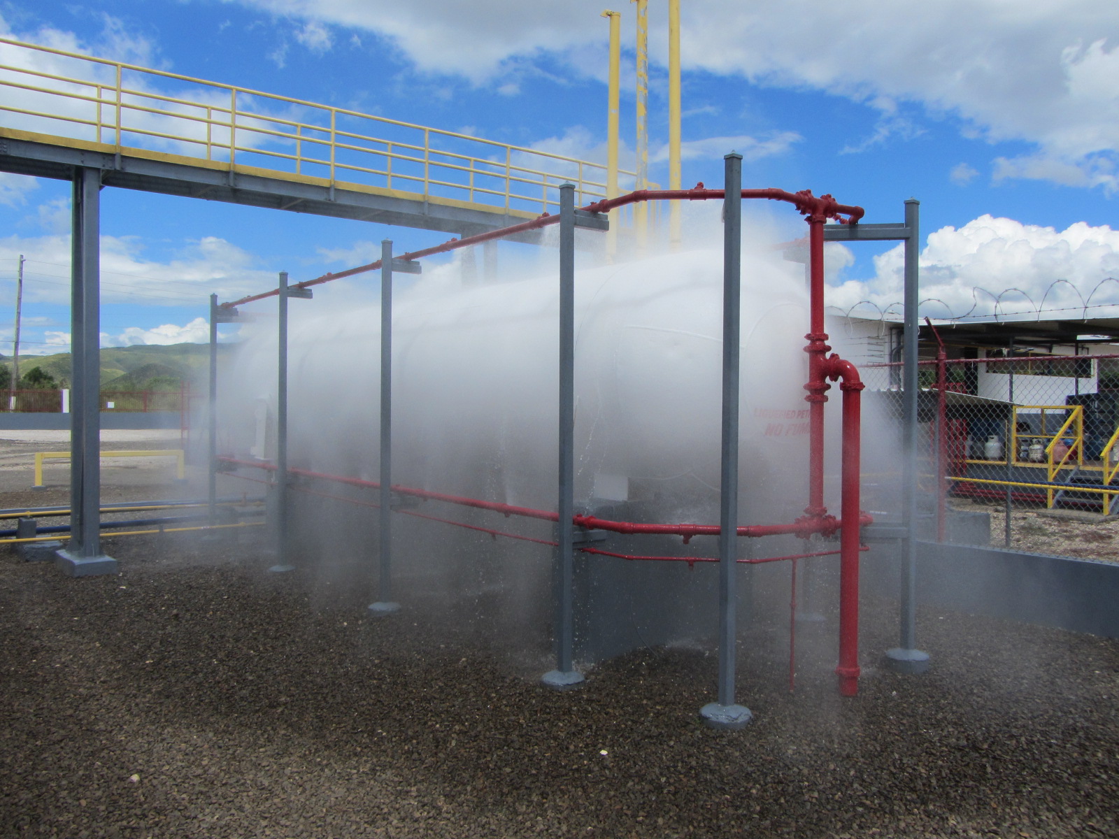Activated deluge flood fire suppression system discharging water from open nozzles after fire detection system triggers valve release